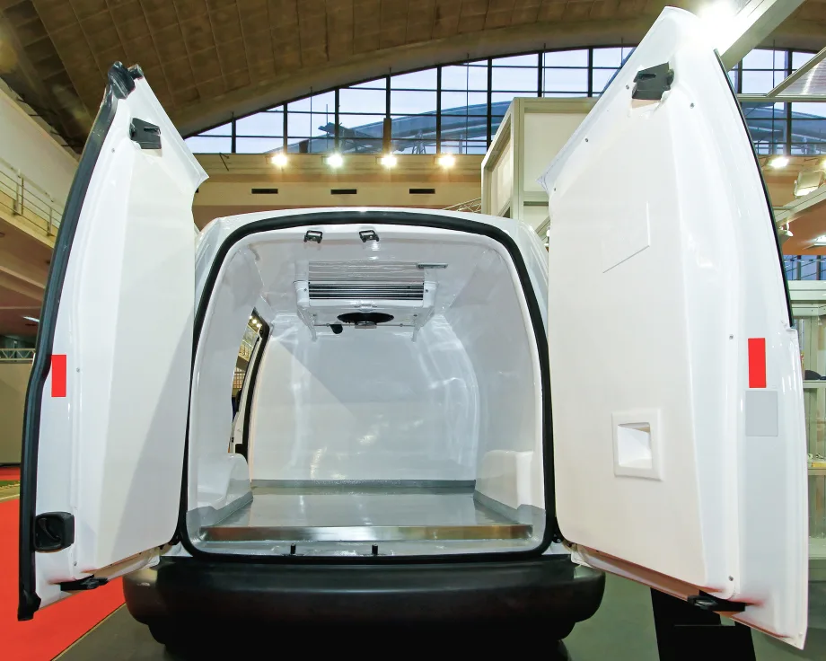 Open rear doors of a refrigerated van showing the insulated cargo box and ceiling-mounted cooling unit