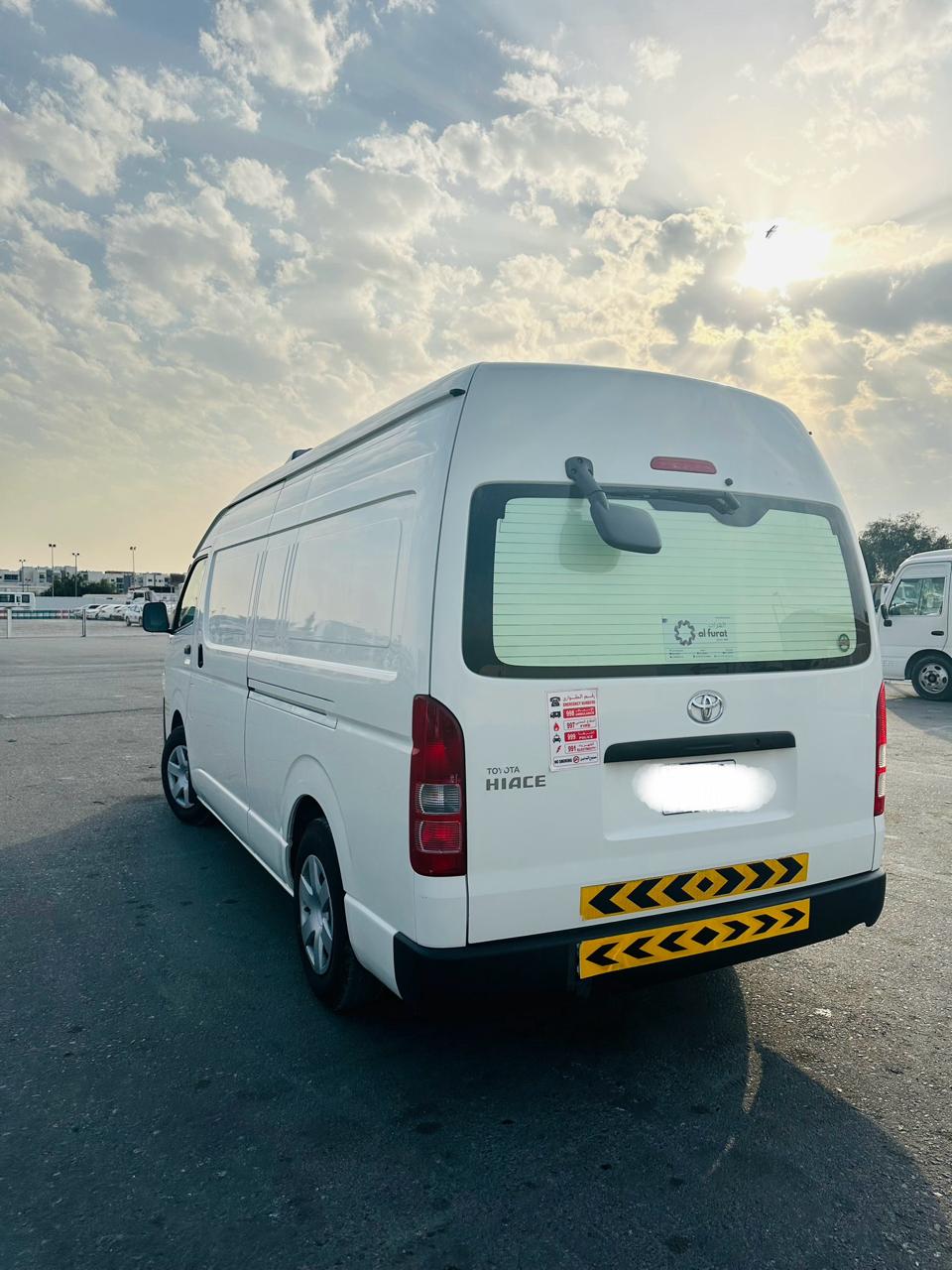 White chiller van for rent in UAE parked near delivery warehouse